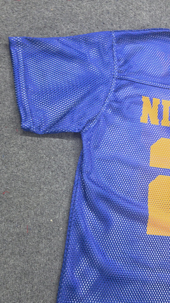 Royal blue mesh jersey with gold “NINETEEN” text and number 22 laid flat on gray background