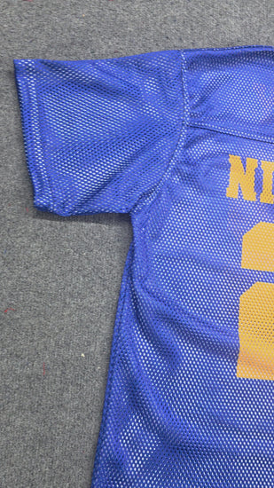 Royal blue mesh jersey with gold “NINETEEN” text and number 22 laid flat on gray background